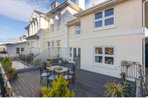 a house with a deck with a table and chairs at Pittman Apartment A Luxury Sea View Apartment in Torquay