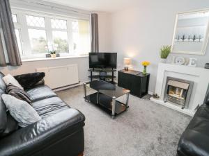 a living room with a couch and a fireplace at 17 Ffordd Gwenllian in Llanfairpwllgwyngyll