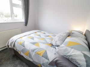 a bedroom with a bed and a window at 17 Ffordd Gwenllian in Llanfairpwllgwyngyll