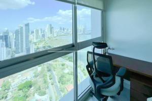 a room with a chair in front of a window at Apartamento Amoblado en Cinta costera Panama largas estadias in Panama City