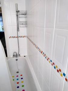 biała łazienka z wanną i prysznicem w obiekcie 2 Bed Flat Near Station with Parking&Comgarden w mieście Sutton