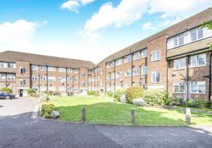 an apartment building with a parking lot in front of it at 2 Bed Flat Near Station with Parking&Comgarden in Sutton