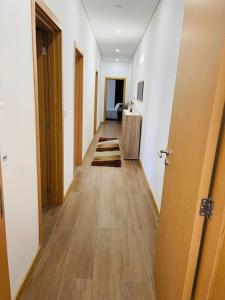 a long hallway with wooden floors and doors at Casa da Tapada in Torre de Moncorvo