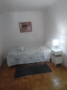 a small bedroom with a bed and a night stand at Casa da Romeira in Elvas