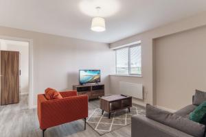 een woonkamer met een bank en een tv bij Bright 2 Bed Apartment Manchester - Sleeps 4 in Manchester