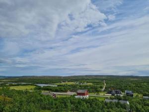 a view of a farm with a barn and a river at Badstue ved elven i Varangerbotn in Varangerbotn +3 photos