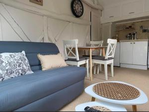 a living room with a blue couch and a table at L'éloge de Vouvray, Orbois in Vouvray