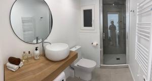 ein Badezimmer mit einem Waschbecken, einem WC und einem Spiegel in der Unterkunft Appartement boho chic près de la plage in Cambrils