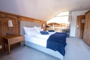 Un dormitorio con una gran cama blanca y una ventana en SL Hotel en Bad Wiessee