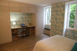 1 dormitorio con 1 cama, escritorio y ventanas en La Maison et son jardin sur le Canal de Bourgogne, en Ravières
