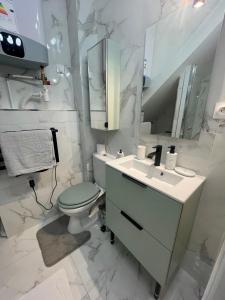 a bathroom with a toilet and a sink and a mirror at Appartement Vincennes proche métro 15 minutes Marais in Vincennes