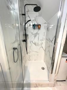 a bathroom with a shower with a glass door at Appartement Vincennes proche métro 15 minutes Marais in Vincennes