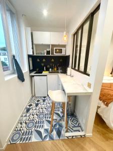 a small kitchen with a table and a stool at Appartement Vincennes proche métro 15 minutes Marais in Vincennes