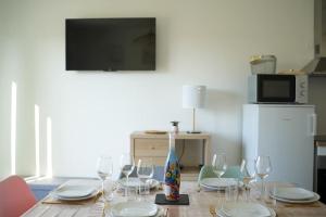uma mesa de jantar com copos de vinho e um vaso em Douceur en Baie, maison neuve - 4 à 6 pers em Saint-Valery-sur-Somme