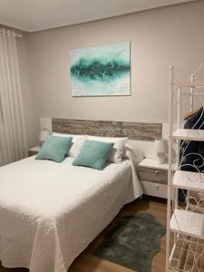 1 dormitorio con 1 cama con sábanas blancas y almohadas azules en Mi Rincón Favorito VT-LR1594, en Rincón de Soto