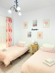 2 camas en una habitación con cortinas rosas en Casa Jazmi­n, en Nerja