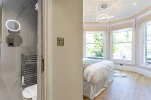 um quarto com uma cama e uma janela em LuxLet Apartments - Heart of Hampstead, London em Londres