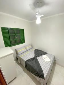 1 dormitorio con cama y ventana verde en Otimo apto com lazer e Wi-Fi em Campo Grande MS, en Campo Grande
