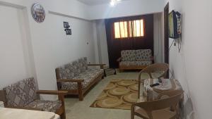 een woonkamer met stoelen en een tafel en een deur bij a lovely cozy flat by the sea in Alexandrië