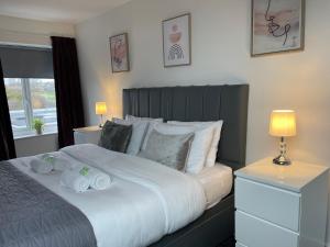 um quarto com uma cama grande com duas toalhas em Holdsworth House Apartments em Killingbeck