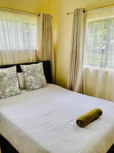 a large bed with a towel laying on it at 25 Swallow Yellowood in Durban
