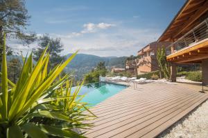 - une piscine avec une terrasse en bois à côté d'une maison dans l'établissement Catalunya Casas Infinity pool and views 20min to Barcelona, à Torrelles de Llobregat