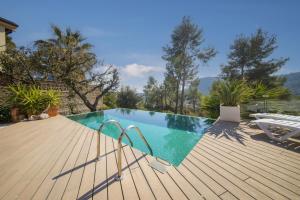 - une piscine avec une terrasse en bois et une piscine dans l'établissement Catalunya Casas Infinity pool and views 20min to Barcelona, à Torrelles de Llobregat
