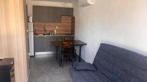 eine Küche mit einem Sofa und einem Tisch in einem Zimmer in der Unterkunft le cabanon in Roquebrune-Cap-Martin