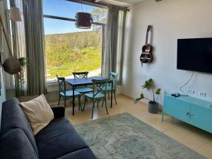 a living room with a couch and a table with chairs at Ein Hod - Artists Village in ‘En Hod