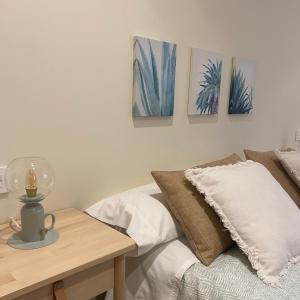 Un dormitorio con una cama y una mesa con pinturas en la pared. en El apartamento de Andrea, Callao3gijon en Gijón