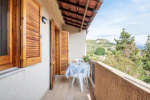 a balcony with a table and a view of the mountains at Sant'Alessio Village in SantʼAlessio Siculo