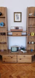 a wooden book shelf with a tv on it at Trosoban stan u Zenici in Zenica