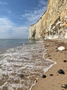 a beach with rocks and water and a cliff at Cairo House in Peacehaven