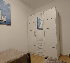 - une chambre avec une grande armoire blanche et un lit dans l'établissement Apartman B&Đ Split, à Split
