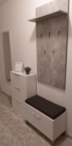 - une commode blanche avec un banc dans une pièce dans l'établissement Apartman B&Đ Split, à Split