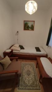 Zimmer mit einem Bett, einem Sofa und einem Tisch in der Unterkunft Londira Apartman Hévíz in Hévíz