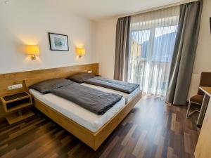 1 dormitorio con cama y ventana grande en Appartement Haus Talblick, en Kaprun