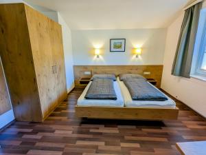 dwa łóżka w pokoju z dwoma lampami na ścianie w obiekcie Appartement Haus Talblick w Kaprunie