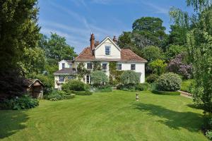 a large white house with a grass yard at The Old Rectory, Kettlebaston in Lavenham