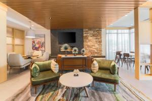 a living room with two chairs and a table at Fairfield by Marriott Inn & Suites Cape Coral North Fort Myers in Cape Coral