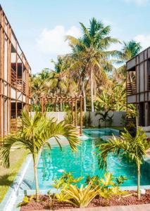 圣米格尔-杜斯米拉格里斯Villa Kamby 103B的建筑物前有棕榈树的游泳池