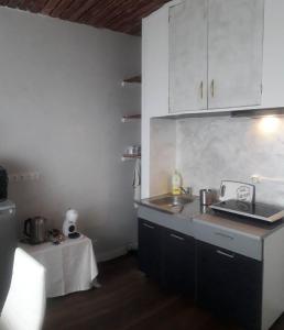 a kitchen with white cabinets and a sink and a table at Pilve apartment in Võru