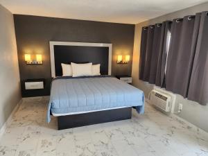 Schlafzimmer mit einem Bett mit blauer Decke in der Unterkunft Relax inn in Frostproof