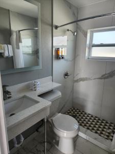 ein Badezimmer mit einem WC, einem Waschbecken und einem Spiegel in der Unterkunft Relax inn in Frostproof