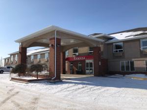 a large brick building with an arch in a parking lot at Ramada by Wyndham Ponoka in Ponoka