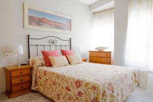 1 dormitorio con 1 cama con almohadas rojas en Piso Céntrico Plaza San Miguel, en Córdoba