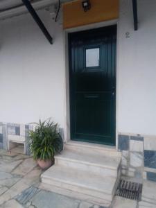 eine schwarze Tür auf einem weißen Haus mit Topfpflanze in der Unterkunft Casas da Saibreira - nº2 in Elvas