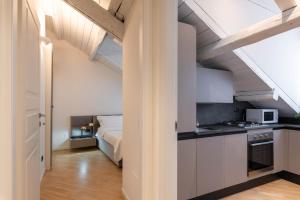ミラノにあるBrera Flat Near Duomoの白いキャビネット付きのキッチン、ベッド1台が備わる客室です。