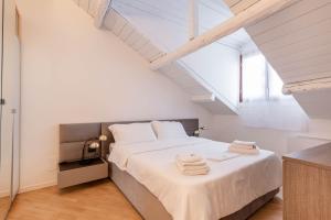 una camera da letto con un grande letto bianco con asciugamani di Brera Flat Near Duomo a Milano