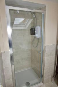 a shower with a glass door in a bathroom at Cottage in Framlingham in Framlingham
